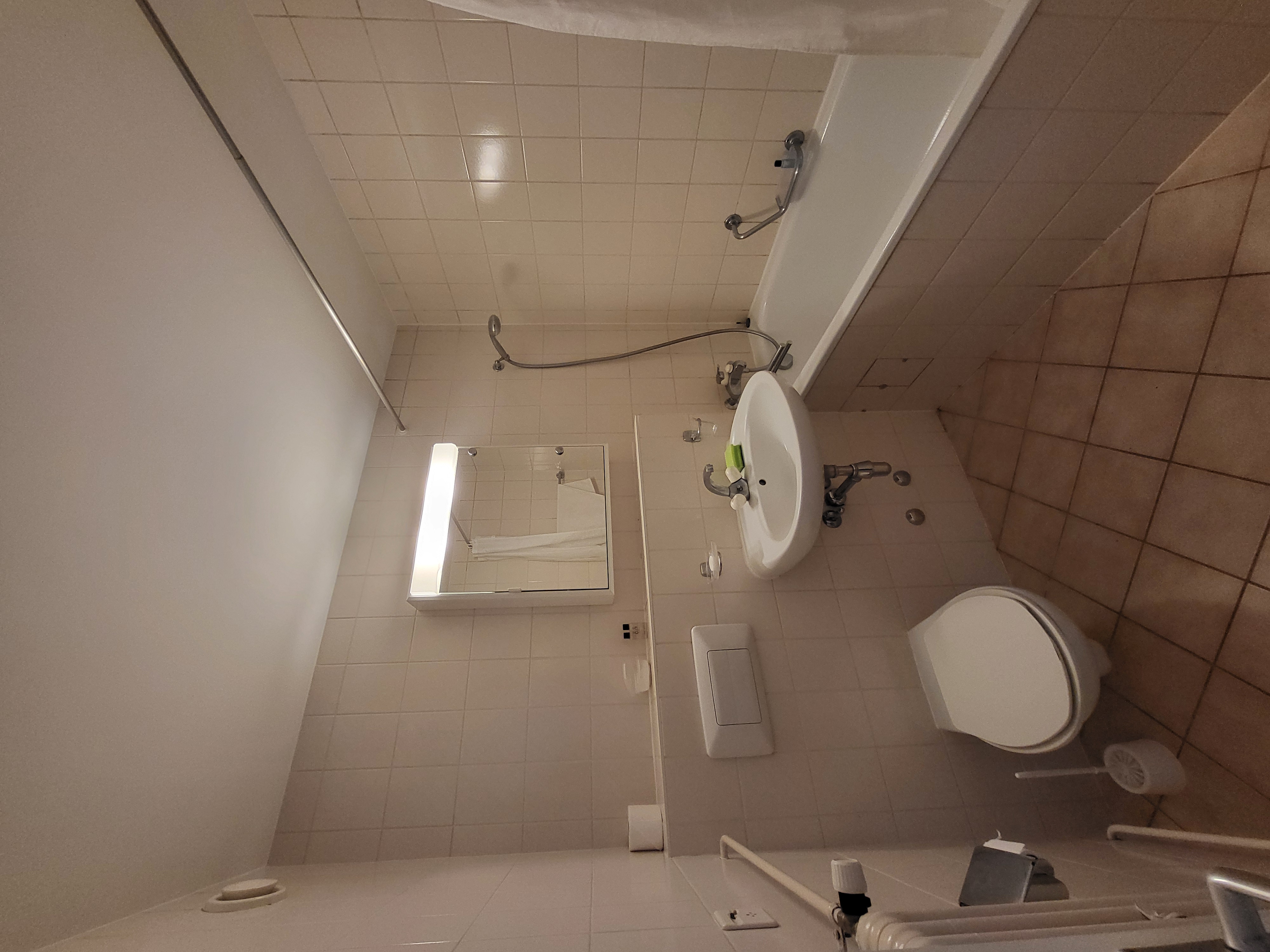 Image of the apartment's bathroom, with bathtub, toilet and washbasin