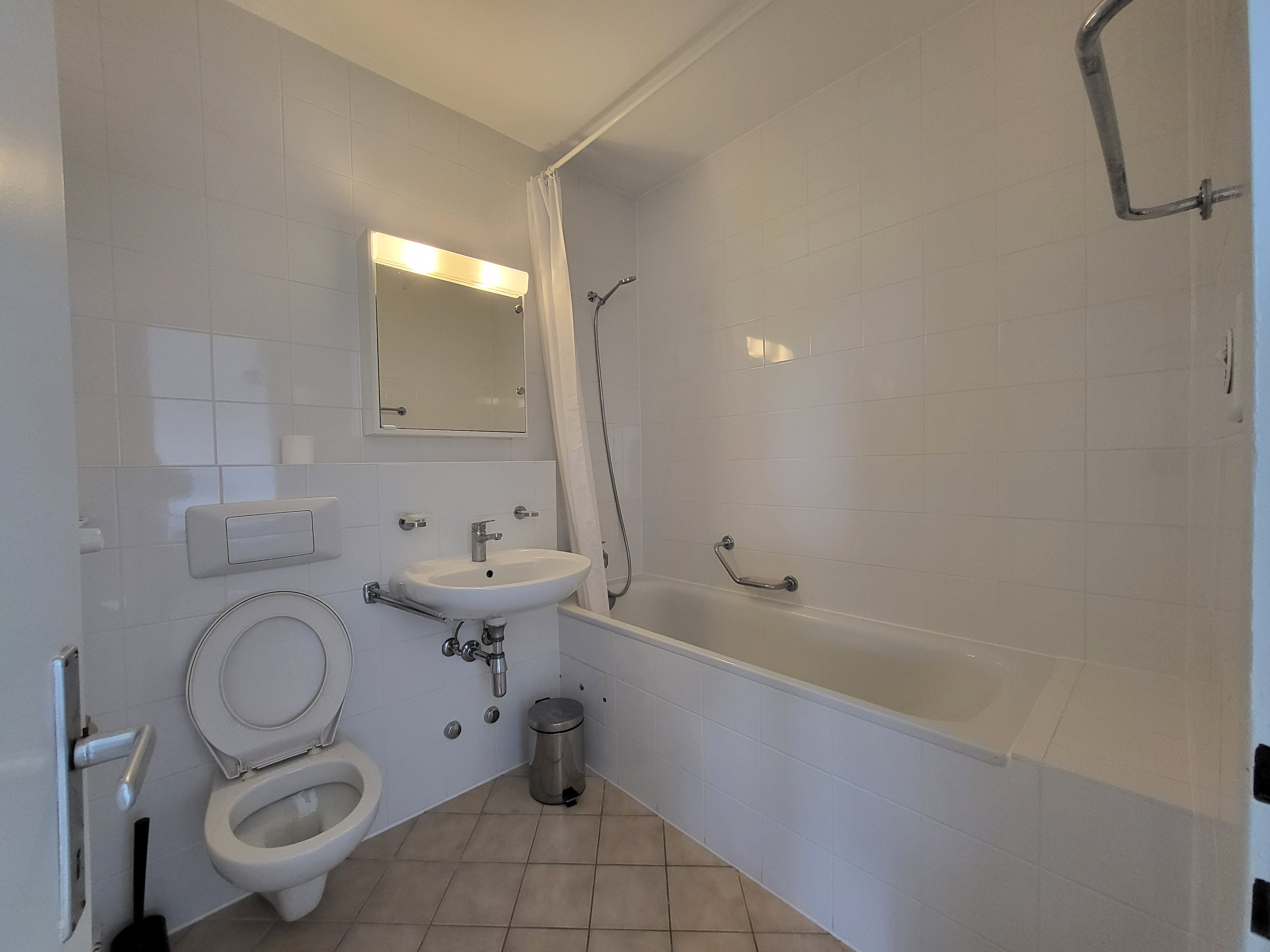 Image of the apartment's bathroom, with bathtub, toilet and washbasin