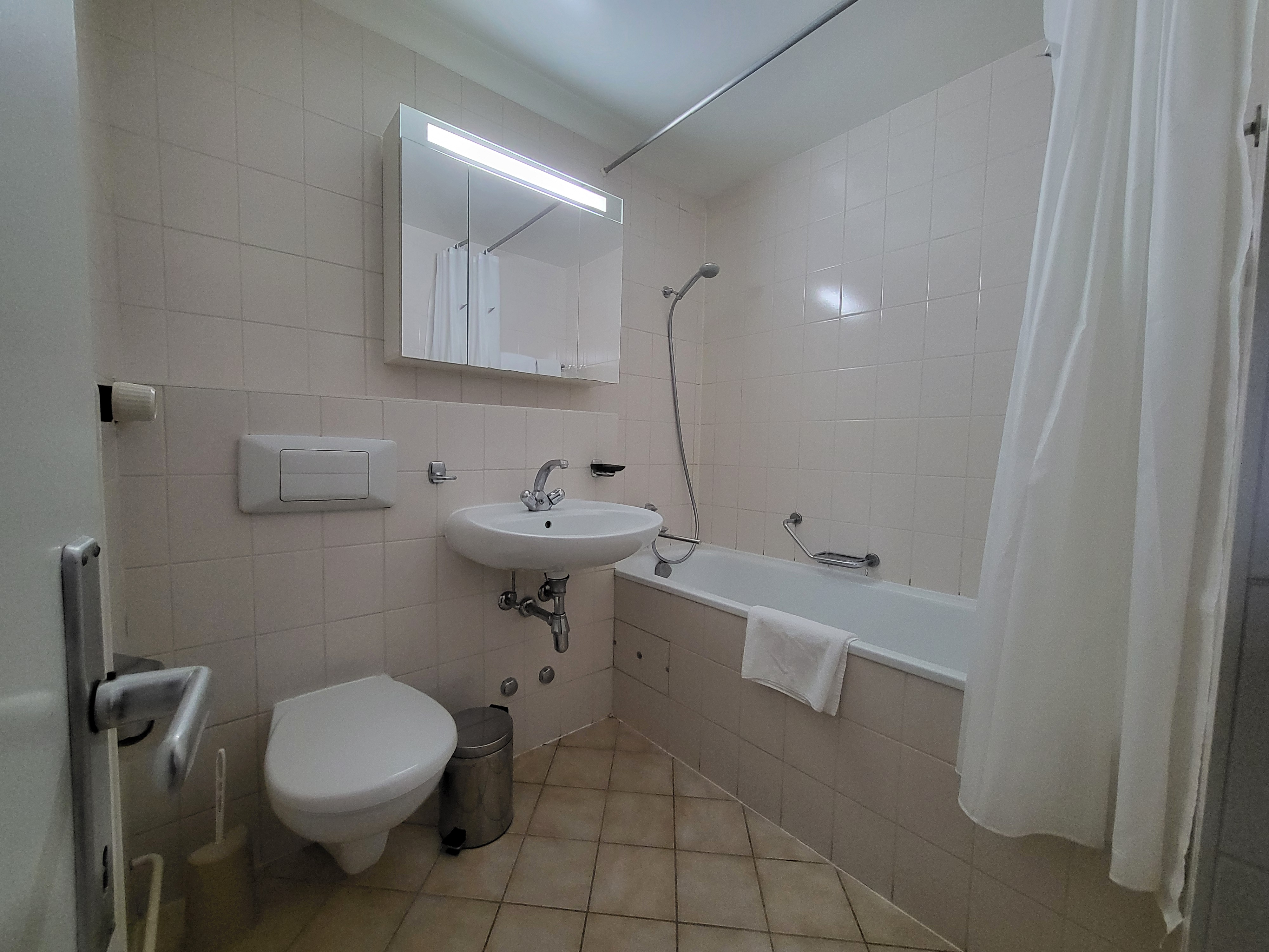Image of the apartment's bathroom, with bathtub, toilet and washbasin