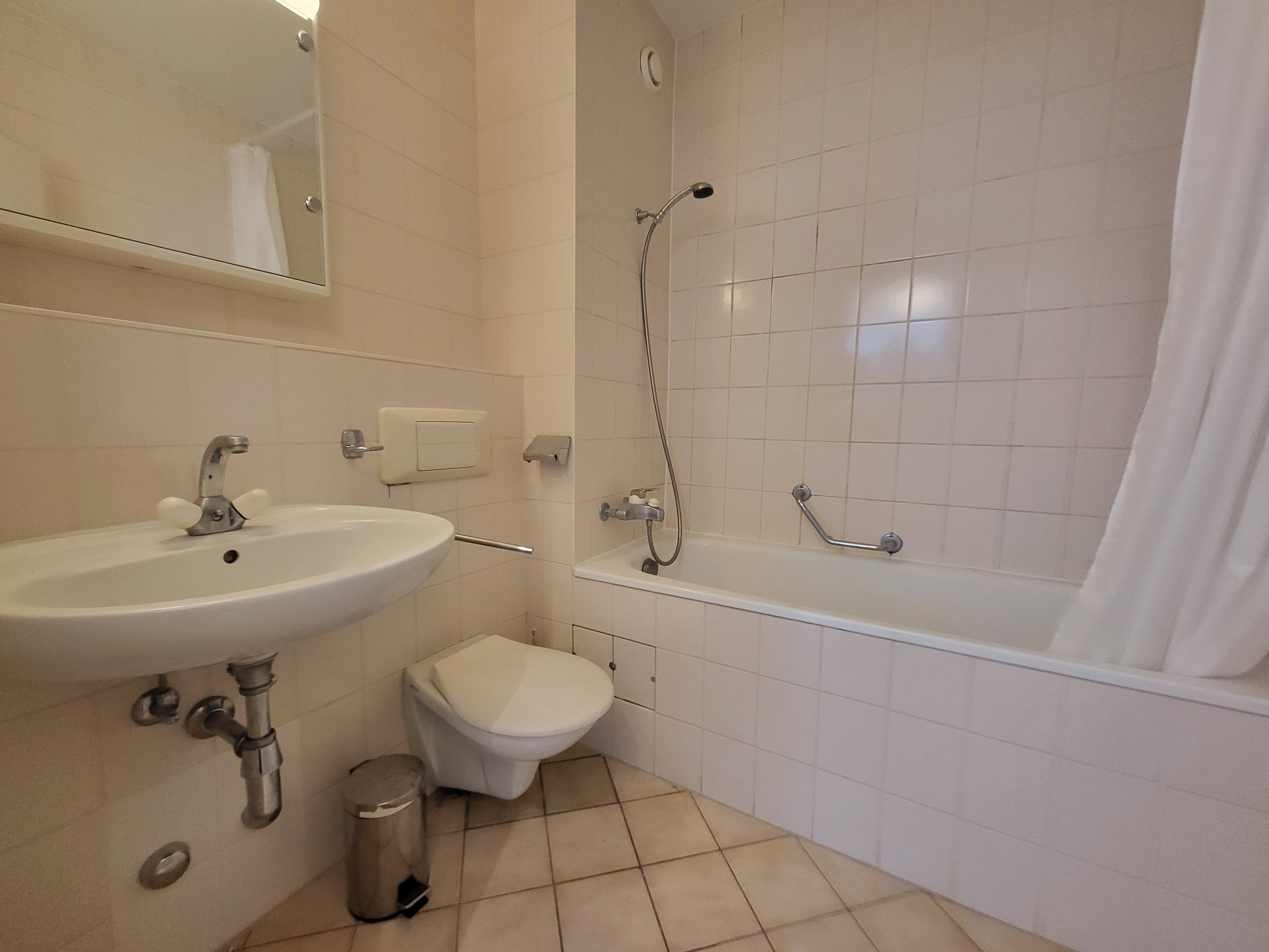 Image of the apartment's bathroom, with bathtub, toilet and washbasin