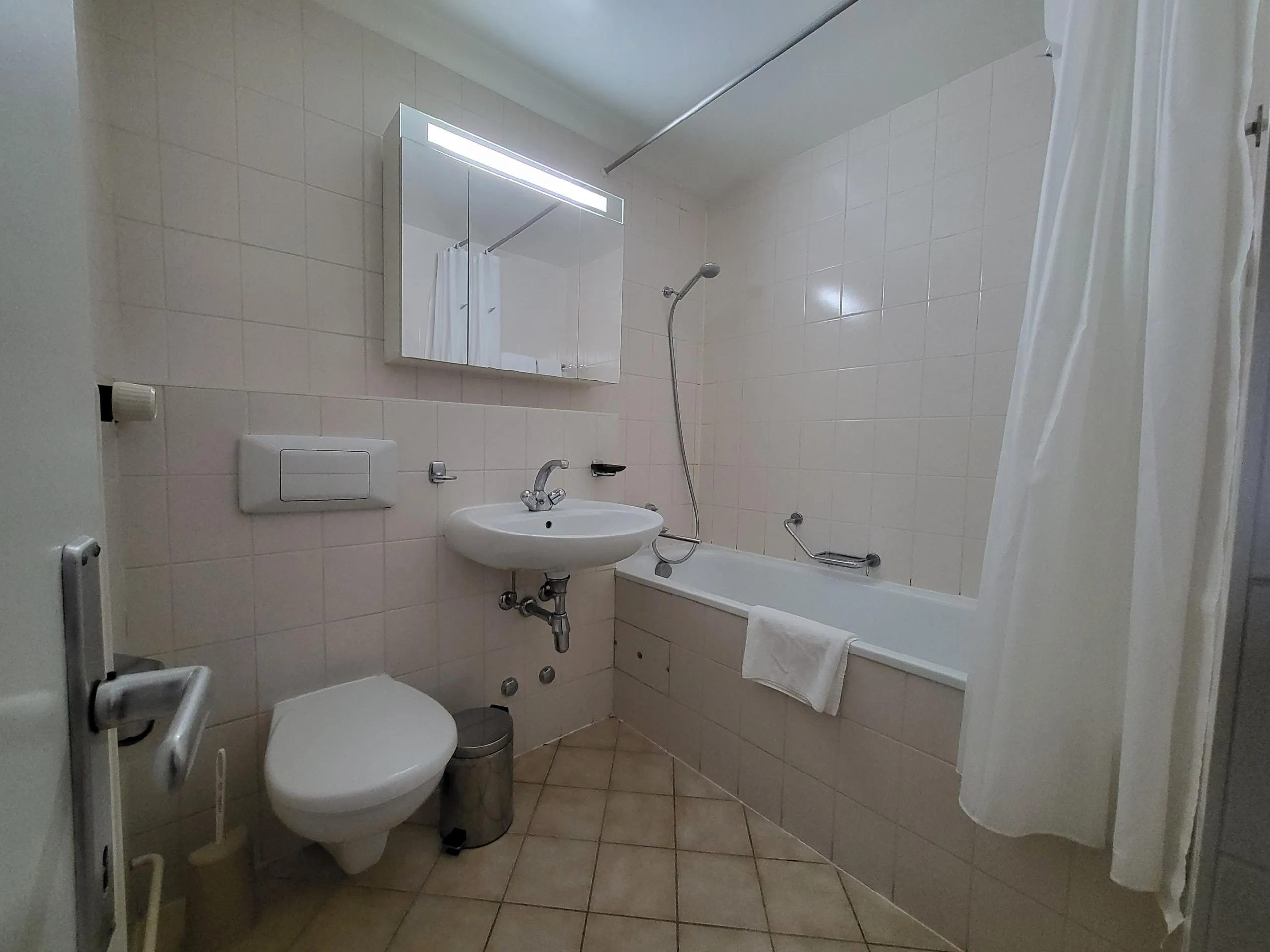 Image of the apartment's bathroom, with bathtub, toilet and washbasin