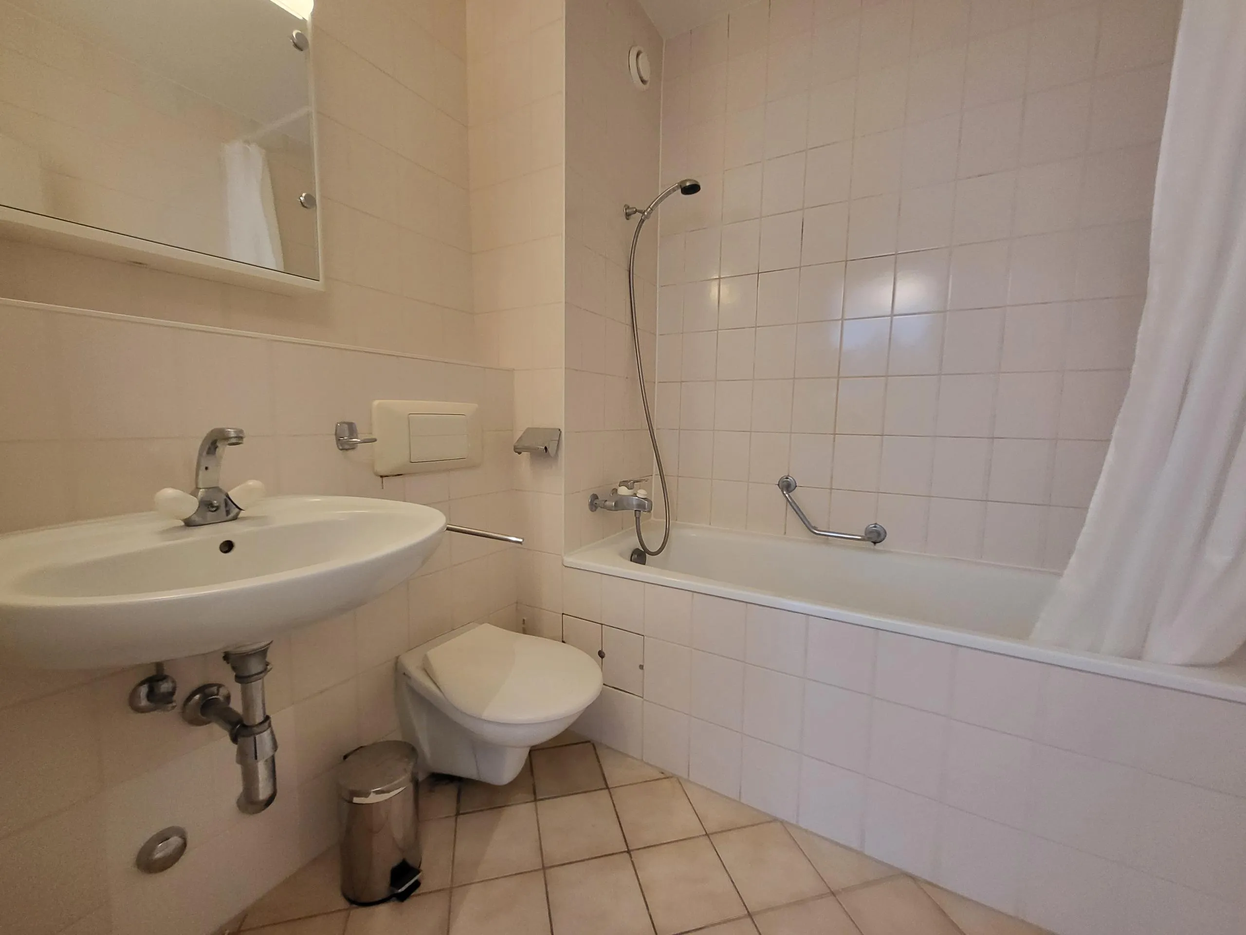 Image of the apartment's bathroom, with bathtub, toilet and washbasin